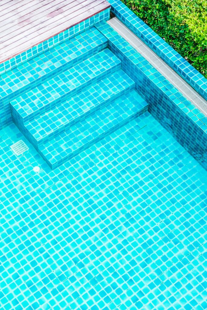 Fiberglass pool with turquoise tiled steps and smooth surface, highlighting energy efficiency and sleek design for outdoor spaces in Purchase, NY.
